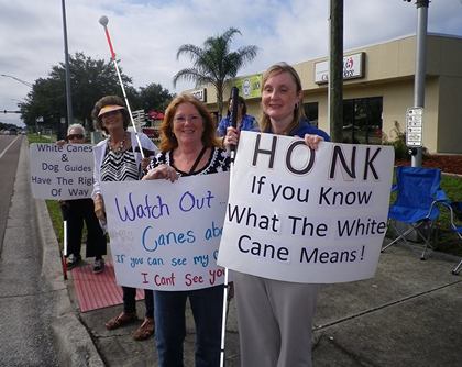 White cane event attendees with signs